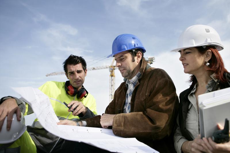 En arbetsgrupp inom byggledningen diskuterar ritningarna.